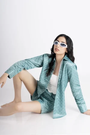 Sea green colored co-ord set which comes with a shirt and shorts, has geometric print on it. shirt has full sleeves, collar and buttons at front. Shorts has two pockets. Perfect for summers and resort wear.
